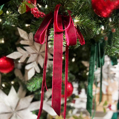 A deep red Non-Wired Velvet Ribbon forms a bow on a Christmas tree, featuring plush texture. Ideal for holiday decor, gift wrapping, and crafting. | LaRibbons and Crafts