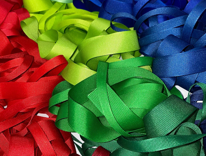 This is the Premium Textured Grosgrain Ribbon series, with stacks of grosgrain ribbons in vibrant colors and distinct ribbed texture, perfect for crafting and gift wrapping.