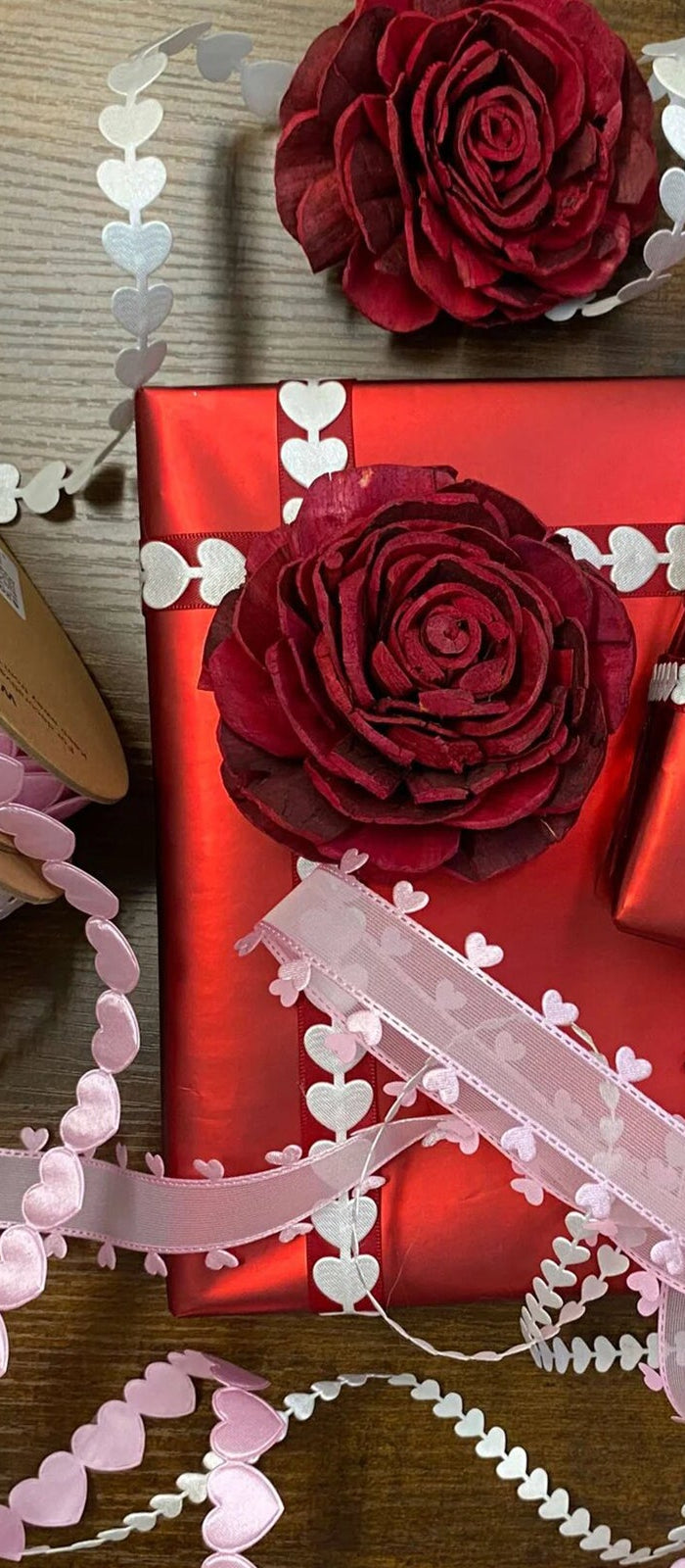 LaRibbons ultrasonic laser cut trims with heart patterns, paired with red rose accents on gift wraps. Ideal for elegant crafts and professional gift wrapping. 丨 LaRibbons and Crafts