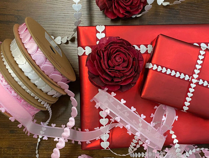 LaRibbons ultrasonic laser cut trims with heart patterns, paired with red rose accents on gift wraps. Ideal for elegant crafts and professional gift wrapping. 丨 LaRibbons and Crafts