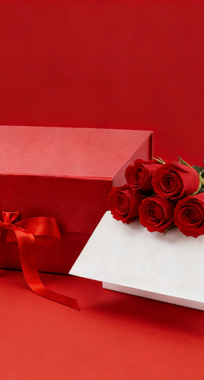 Red roses bouquet, gift box, romantic Valentine's Day gift setup on red background.