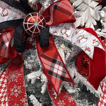 Festive ribbons with snowman, plaid, and snowflake designs adorn a flocked Christmas tree for a cheerful holiday look.