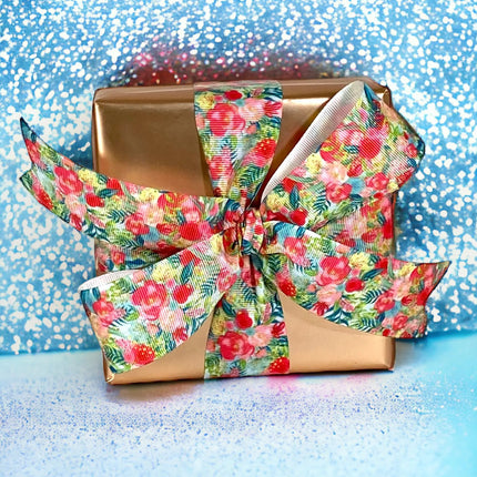 Rose gold matte-wrapped gift + floral satin bow; festive gifting.