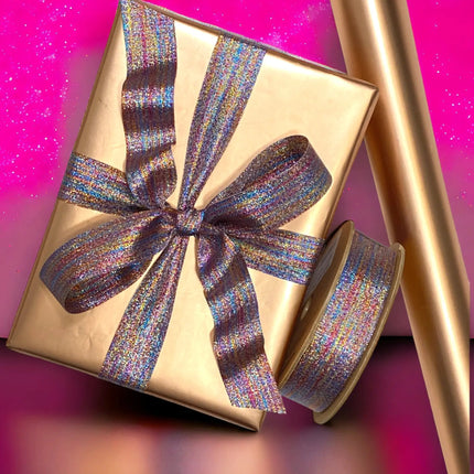 Rose gold matte-wrapped gift + iridescent ribbon; celebratory gifting.