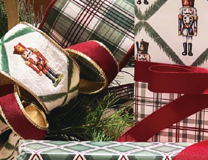 Christmas gifts with plaid wrapping, red satin bows, nutcracker-printed ribbon, plus pinecones and greens—full of festive charm.