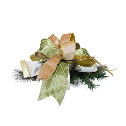 Festive Christmas decor with a large bow (green, gold, white) on pine greenery