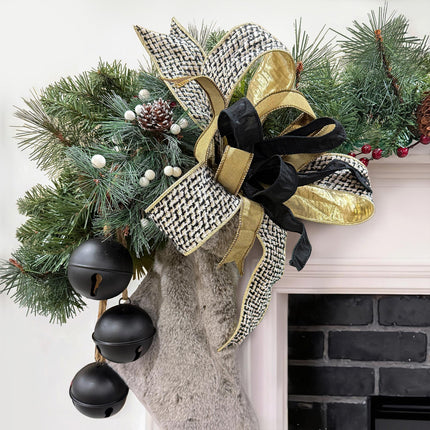 Christmas fireplace garland: houndstooth bow, gold/black ribbons, pine, bells & fuzzy stockings.