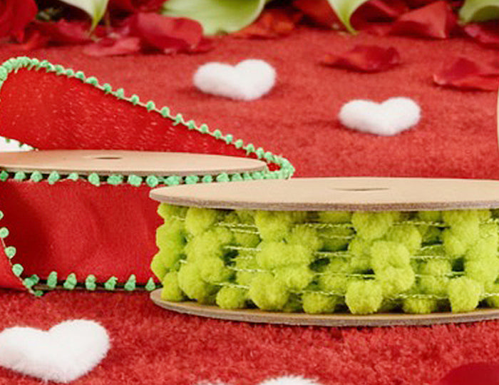 Pom pom trims (red, green, white) on red background with roses – for festive crafts