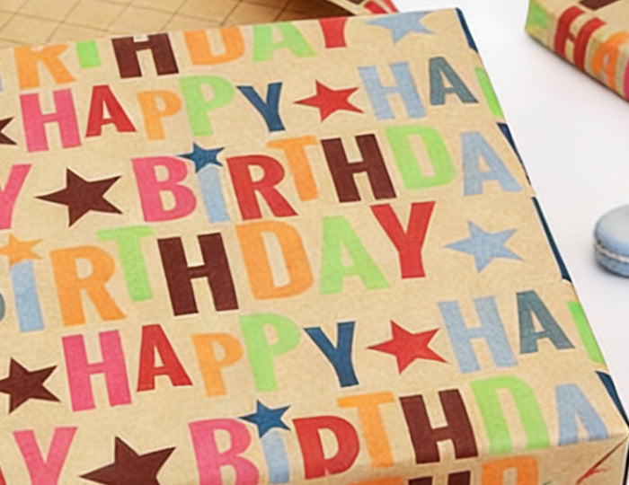 Kraft wrapping paper (colorful "Happy Birthday"+stars) — sturdy, perfect for birthday gift wrapping.