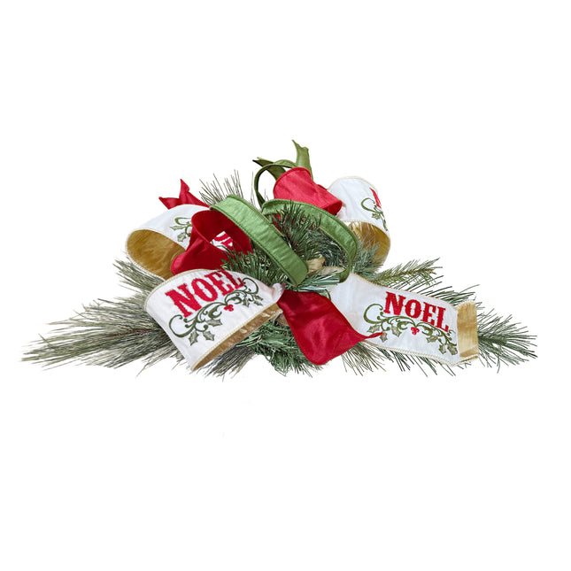 A Christmas decoration featuring green pine branches adorned with red, green, and white "NOEL" printed ribbons.