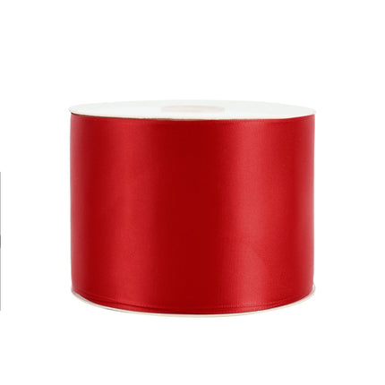 Spooled red double face satin ribbon, suitable for holiday decor, handmade card designs.