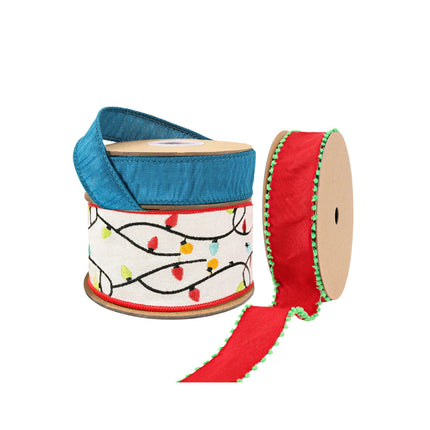 Three spools of festive ribbons: blue, Christmas light-patterned white, and red with green pom-pom trim.