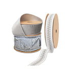 Three spools of premium silver Christmas ribbons: sparkling sequined, soft velvet, and delicate lace-patterned, boasting intricate textures and eye-catching designs.