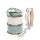 Four spools of decorative ribbons: two light blue, one white, and one white with silver floral embroidery.