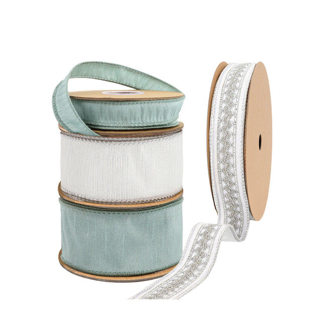 Four spools of decorative ribbons: two light blue, one white, and one white with silver floral embroidery.