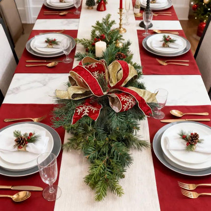 Christmas dining table centerpiece with a lush pine arrangement and a red-gold ribbon bow, creating an elegant and festive ambiance for holiday celebrations.