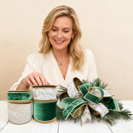 Woman with four Christmas ribbon rolls & bow on table. Velvet, patterned (gold details).