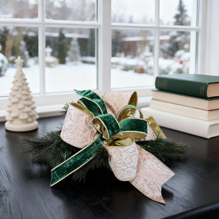Christmas bow: dark green velvet & beige pattern ribbons on dark table by window. Sophisticated textures.