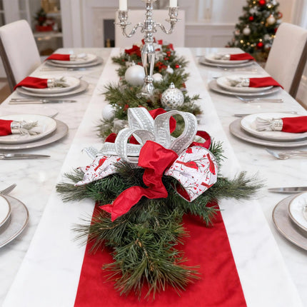 Christmas ribbon decor on dining table – red, cardinal-printed, silver lace ribbons on pine.