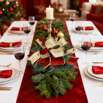 Christmas ribbon decor on dining table – Red, gold ribbons on pine, festive table setting.
