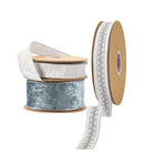 Assorted ribbon spools (blue velvet, white with silver embroidery, textured white) for holiday decorating, gift wrapping, crafts.