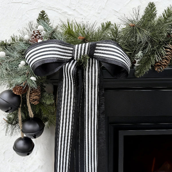 Black-white striped ribbed ribbon bow on Christmas greenery (with pinecones)
