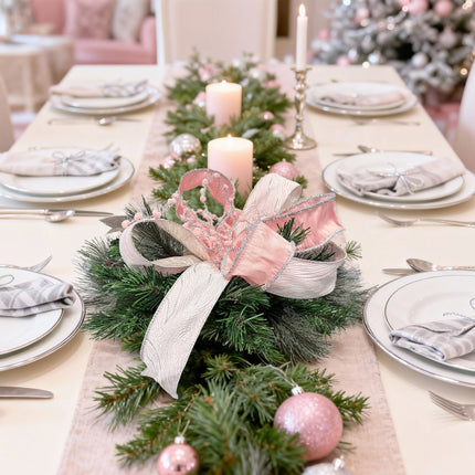Dining table centerpiece: pink bow + pine/silver balls – elegant holiday vibe.