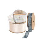 Assorted gift wrapping ribbons – colorful woven, light pink velvet, gray-blue velvet on spools, ideal for upscale packaging and festive decor.