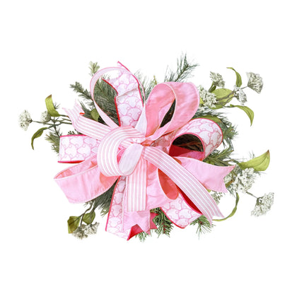 Pink multi-pattern wired ribbon bow with greenery, styled for wreaths, gift toppers, and baby shower decor.