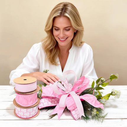 Woman crafting a multi-layered pink bow using bow-pattern, dupioni, and ticking stripe wired ribbons