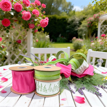Spring ribbon bundle with hot pink dupioni, green velvet stripe, and herb print wired ribbons, styled on a garden table with pink roses and lavender accents.
