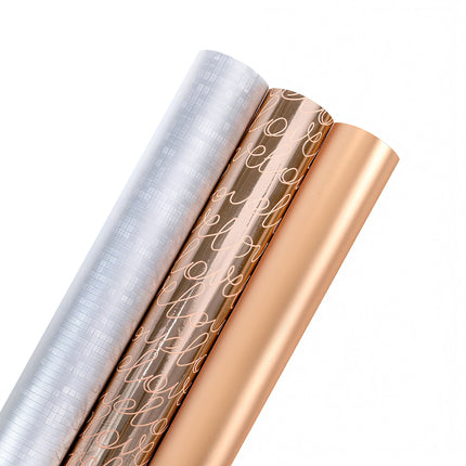 Metallic wrapping paper rolls: silver grid, rose gold "love" script, solid rose gold; gift wrapping.