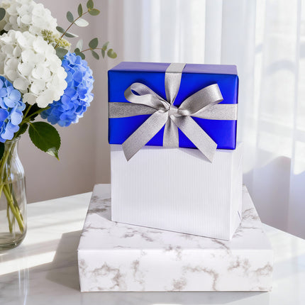 Shiny royal blue gift wrap with silver glitter ribbon bow, for upscale gifts.