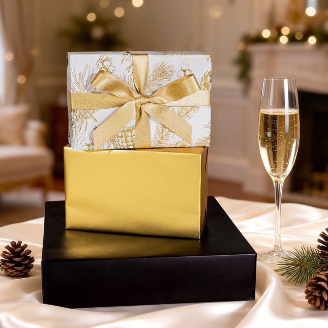 White gift wrap with gold pine patterns, paired with a metallic gold ribbon bow, for holiday gifting.