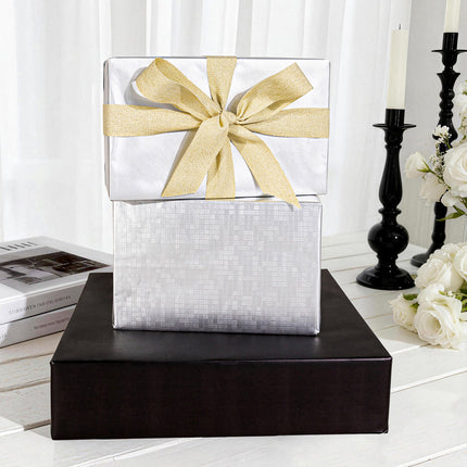 Satin white gift wrap with a wide gold glitter ribbon bow, for elegant events.