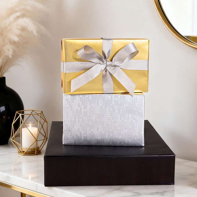 Glossy gold gift wrap with a silver glitter ribbon bow, for luxury presents.