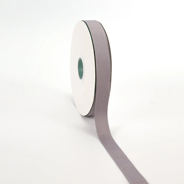 Spool of silver grosgrain ribbon, unrolled to display its textured weave.