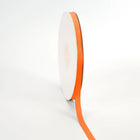 Spool of Torrid Orange grosgrain ribbon, unrolled to display its textured weave.