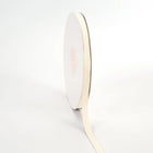 Spool of ivory grosgrain ribbon, unrolled to display its textured weave.