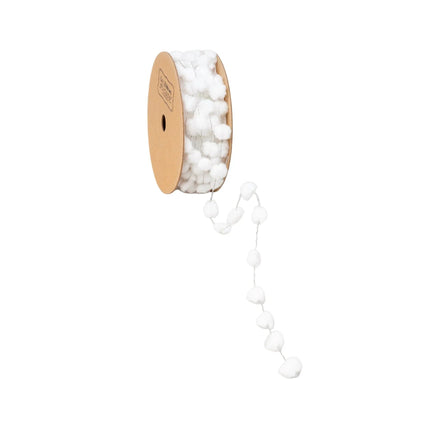 A roll of white pom-pom trim on a cardboard spool, with soft, round pom-poms that bring a whimsical.
