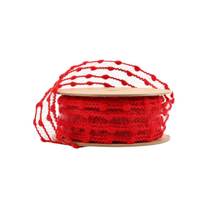 A spool of red decorative ribbon with a textured, featuring loops of sheer mesh with red pom-pom-like accents.