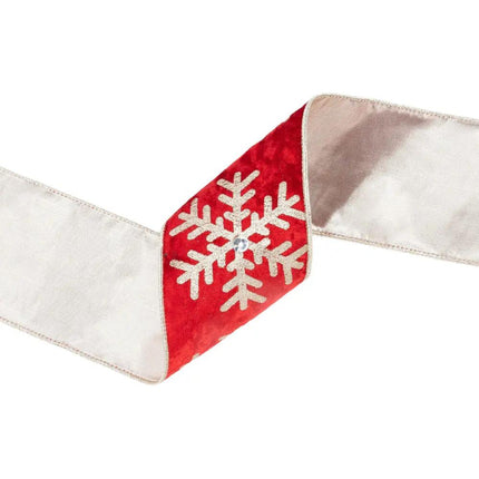 A curled piece of 4" wired velvet ribbon, red with glitter snowflake and jewel on the front, beige backing on the reverse, displaying exquisite craftsmanship.