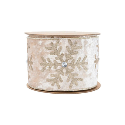 A spool of 4" wired velvet Christmas ribbon, champagne-hued with glittering gold snowflakes and jewel details, ideal for creating luxurious holiday decor.