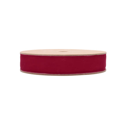A roll of magenta red velvet ribbon, great for embellishing holiday candle holders and creating DIY ornament hangers.