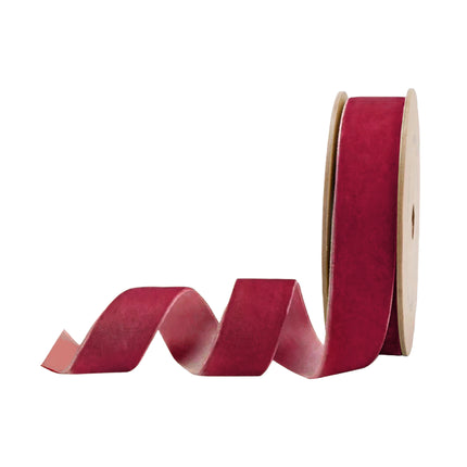 A spool of Magenta red velvet ribbon, ideal for styling festive holiday table settings and Christmas decor.