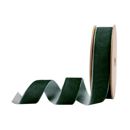 Dark green velvet ribbon on a brown spool, perfect for Christmas decor and creating upscale party favor ties with its rich, elegant finish.