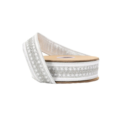 A spool of white ribbon with intricate silver embroidery, ideal for festive decor and DIY crafts.