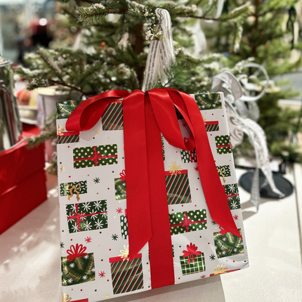 Christmas gift wrapped in green/red gift-patterned paper, accented with a large red single face satin ribbon bow.