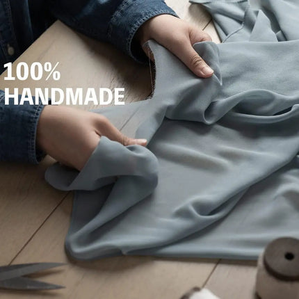 Artisan crafting 100% handmade premium chiffon ribbon from soft, dusty blue fabric, emphasizing quality and hand-finished detail.