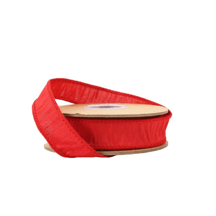 A spool of red ribbon with stitched edges, suitable for crafting or festive decorations.